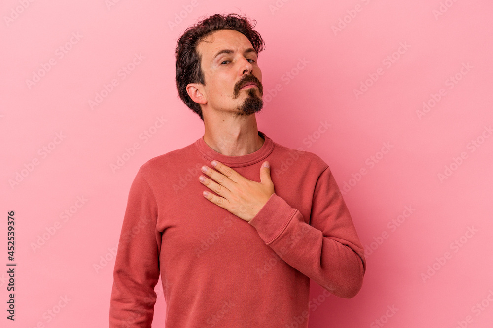 Young caucasian man isolated on pink background taking an oath, putting hand on chest. Young caucasian man isolated on pink background taking an oath, putting hand on chest.