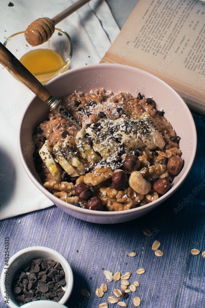 Bowl of oatmeal porridge with banana and nuts. Top view. Healthy vegan breakfast
