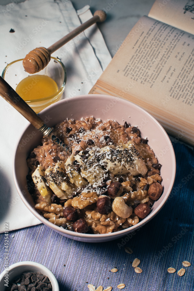 Bowl of oatmeal porridge with banana and nuts. Top view. Healthy vegan breakfast