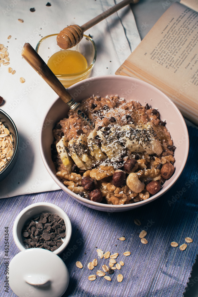 Bowl of oatmeal porridge with banana and nuts. Top view. Healthy vegan breakfast