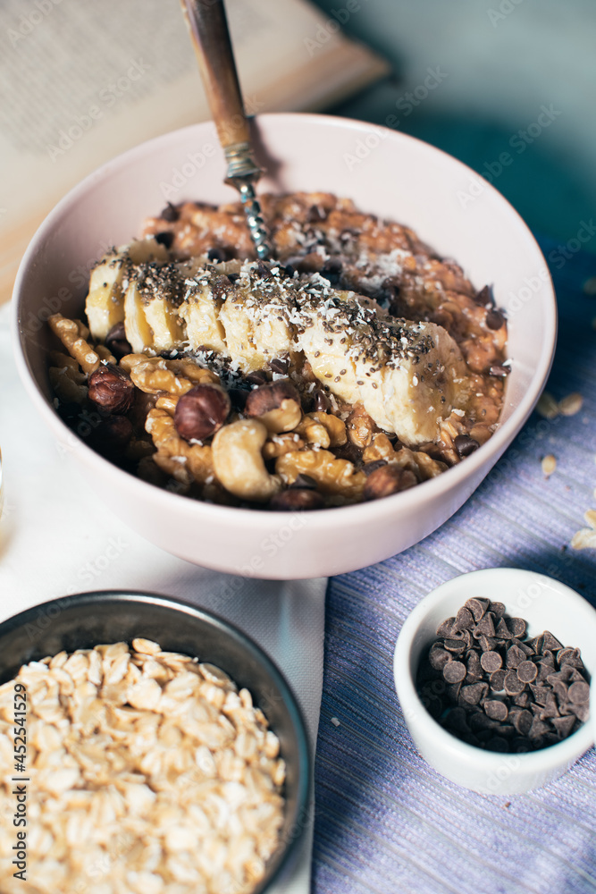 Bowl of oatmeal porridge with banana and nuts. Top view. Healthy vegan breakfast