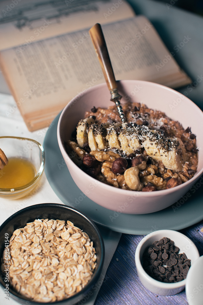 Bowl of oatmeal porridge with banana and nuts. Top view. Healthy vegan breakfast