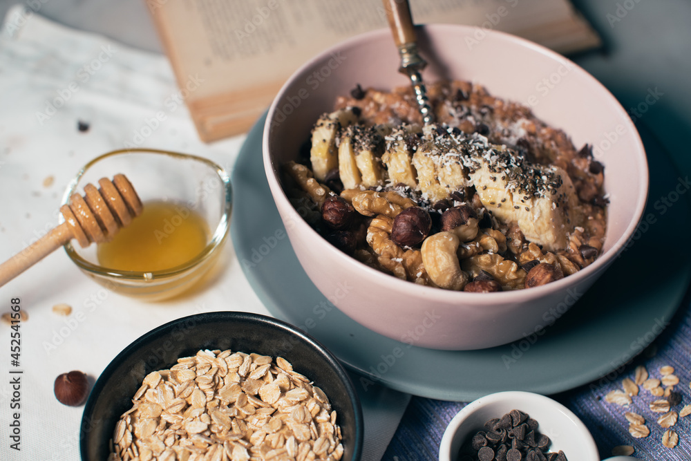 Bowl of oatmeal porridge with banana and nuts. Top view. Healthy vegan breakfast