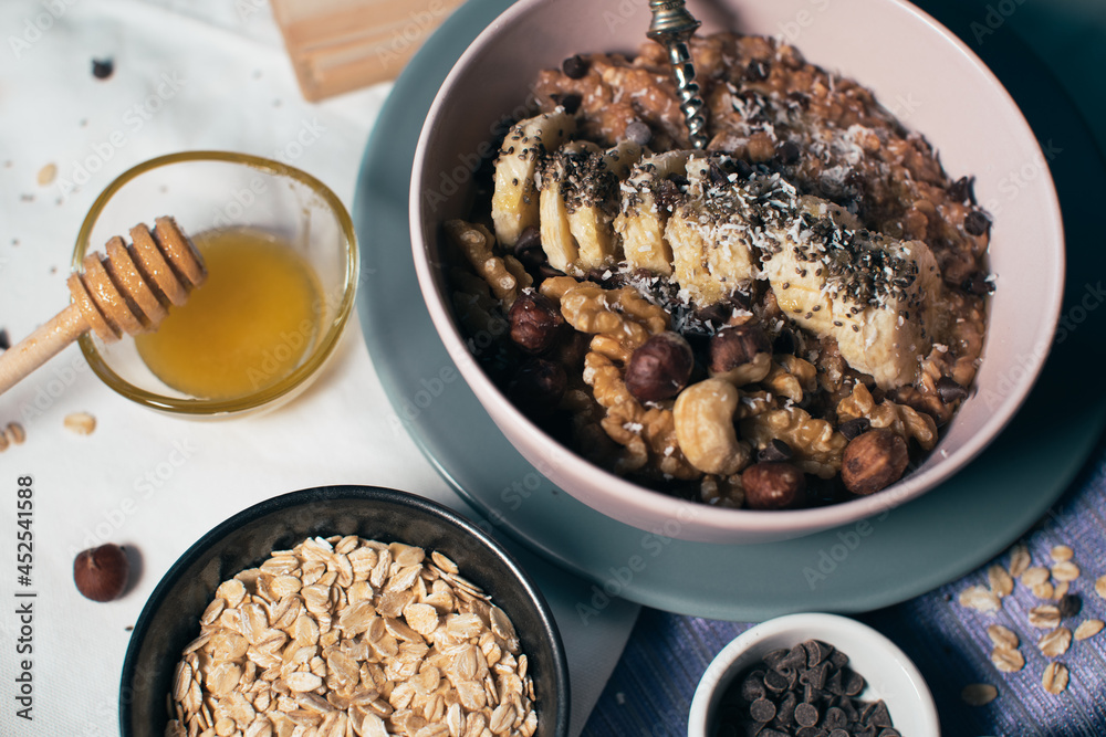 Bowl of oatmeal porridge with banana and nuts. Top view. Healthy vegan breakfast