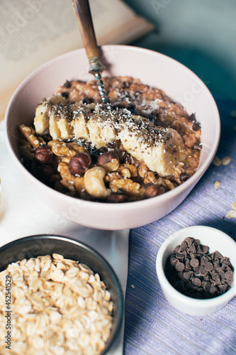 Obraz na płótnie Bowl of oatmeal porridge with banana and nuts. Top view. Healthy vegan breakfast w salonie