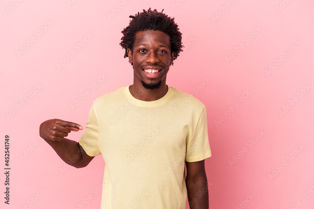Young african american man isolated on pink background person pointing by hand to a shirt copy space, proud and confident