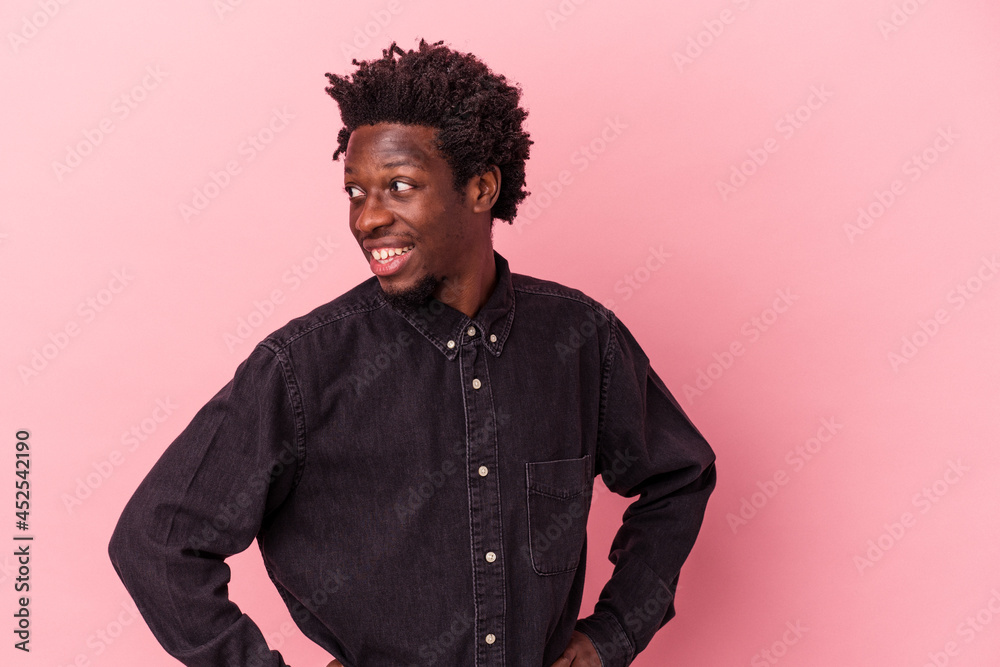 Obraz premium Young african american man isolated on pink background confident keeping hands on hips.