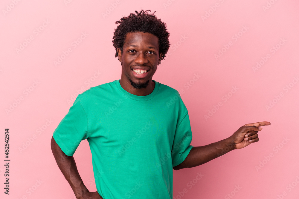 Young african american man isolated on pink background smiling cheerfully pointing with forefinger away. Young african american man isolated on pink background smiling cheerfully pointing with forefinger away.
