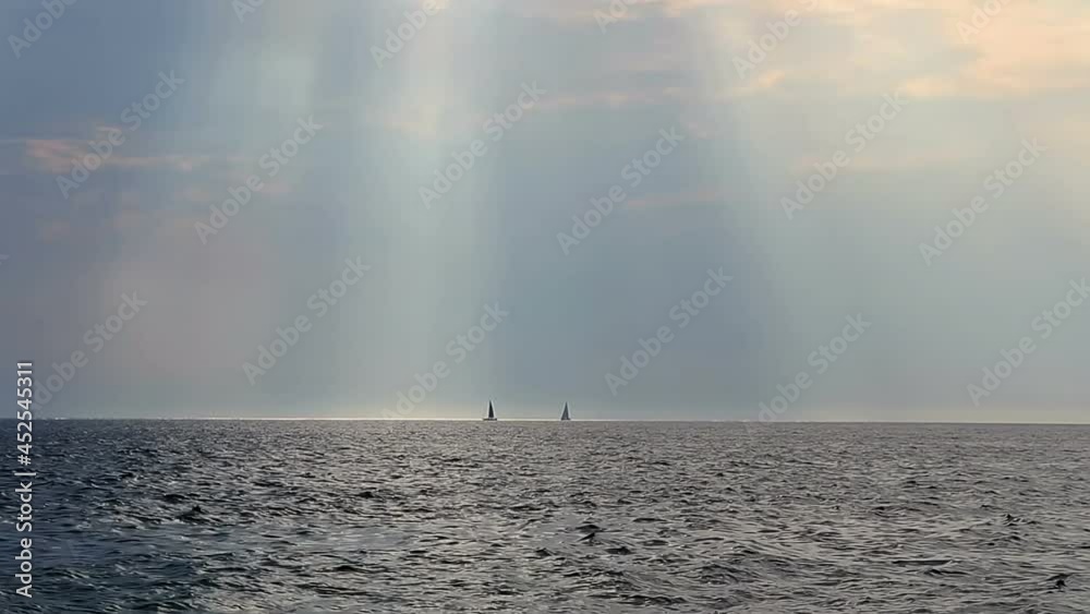Two small sailboat float on Croatia sea with god light and cloudy sky Two small sailboat float on Croatia sea with god light and cloudy sky