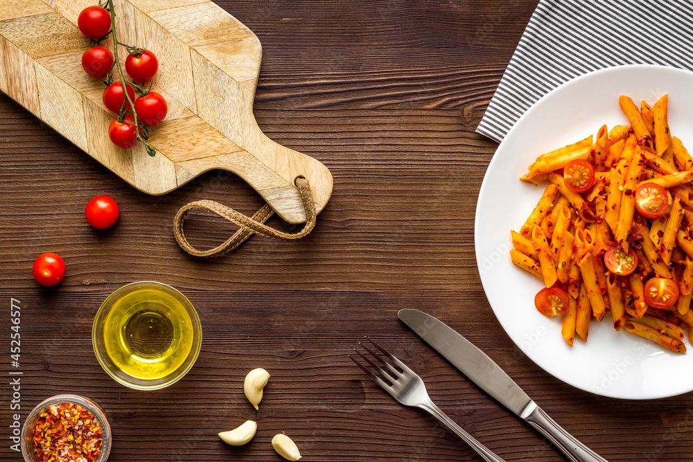 Plate of pasta penne with tomato sauce and herbs