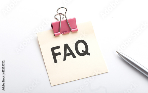 FAQ text on the sticker with pen on the white background