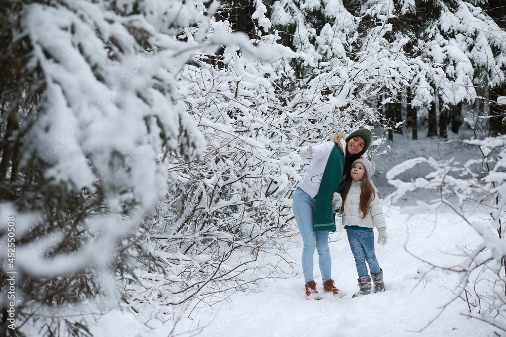 Young family for a walk. Mom and daughter are walking in a winter park. Young family for a walk. Mom and daughter are walking in a winter park.