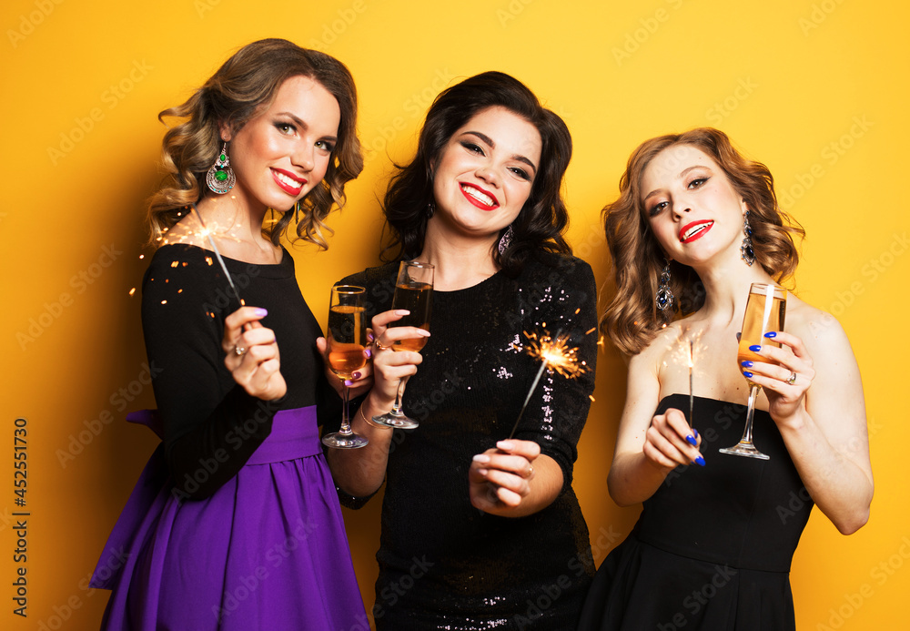 young women with a champagne glasses and sparklers