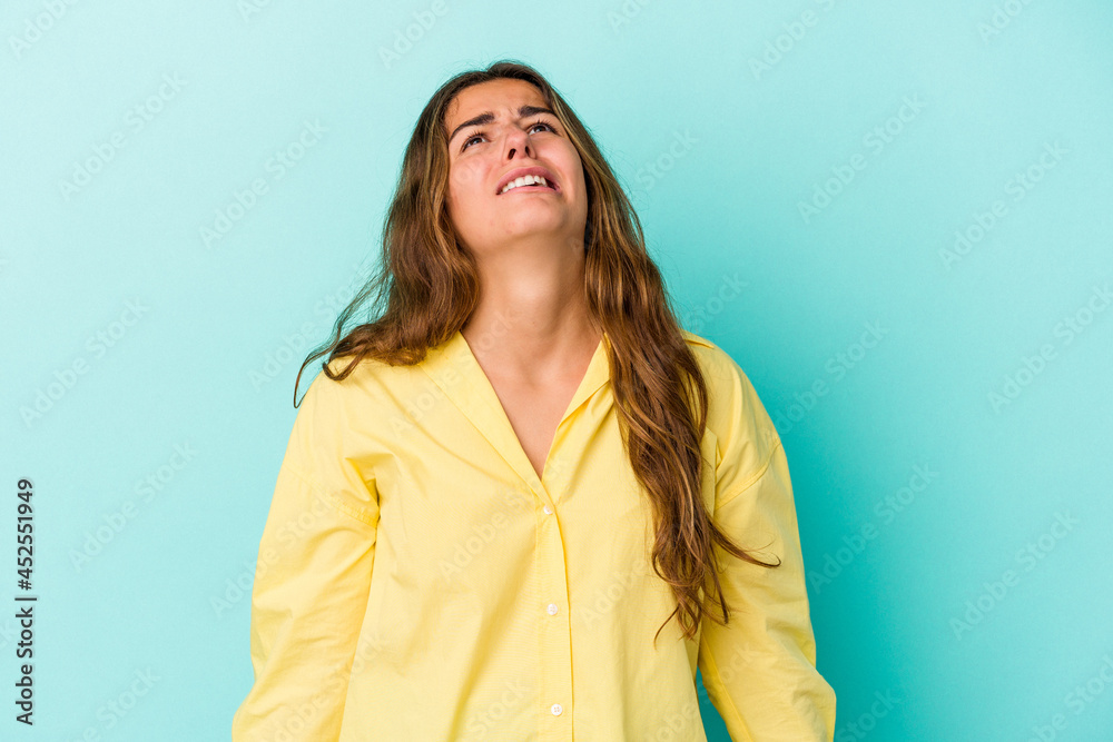 Young caucasian woman isolated on blue background shouting very angry, rage concept, frustrated. Young caucasian woman isolated on blue background shouting very angry, rage concept, frustrated.