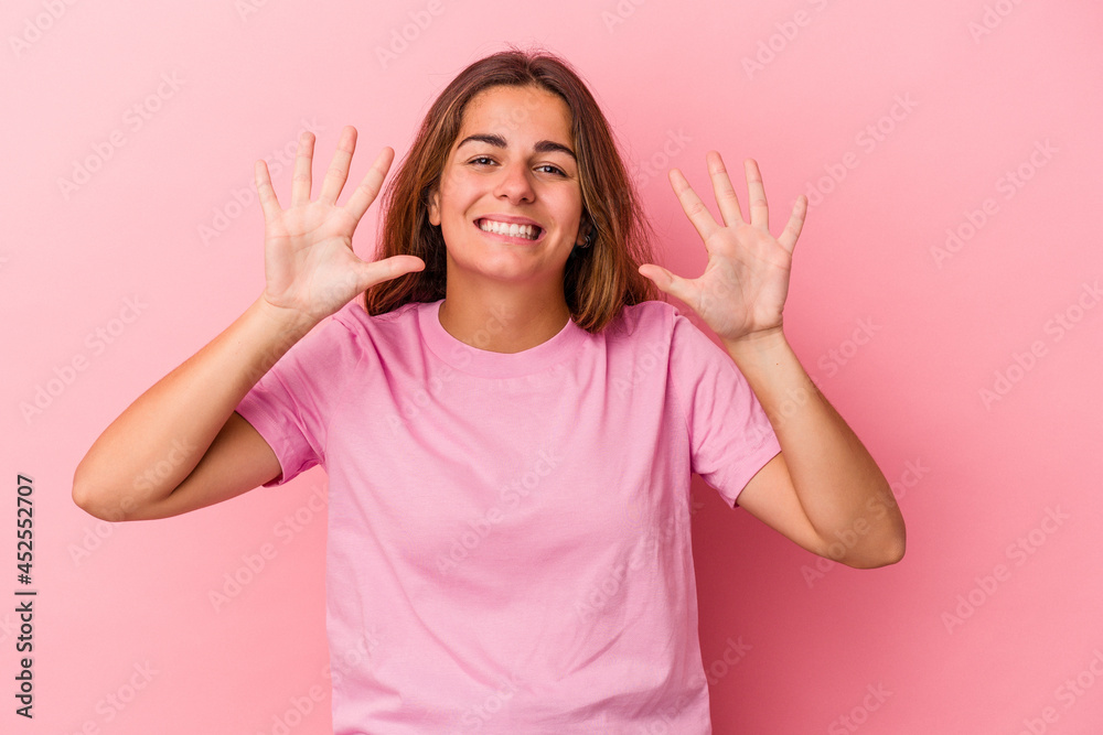 Young caucasian woman isolated on pink background showing number ten with hands. Young caucasian woman isolated on pink background showing number ten with hands.
