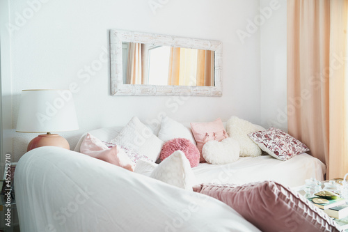 Photo of living room with white sofas and a lot of white and pink pillows