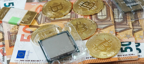 Monedas de Bitcoin o criptomonedas con dinero real en euros de fondo y microprocesadores de ordenador para validar la fuerza del minado de criptomonedas como activos financieros. photo