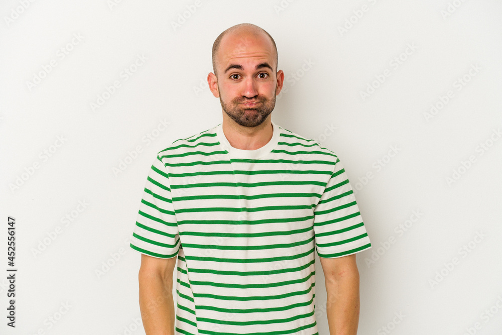 Young bald man isolated on white background blows cheeks, has tired expression. Facial expression concept. Young bald man isolated on white background blows cheeks, has tired expression. Facial expression concept.