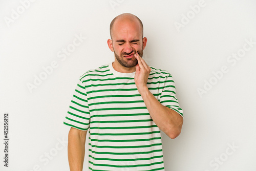 Young bald man isolated on white background having a strong teeth pain, molar ache. © Asier