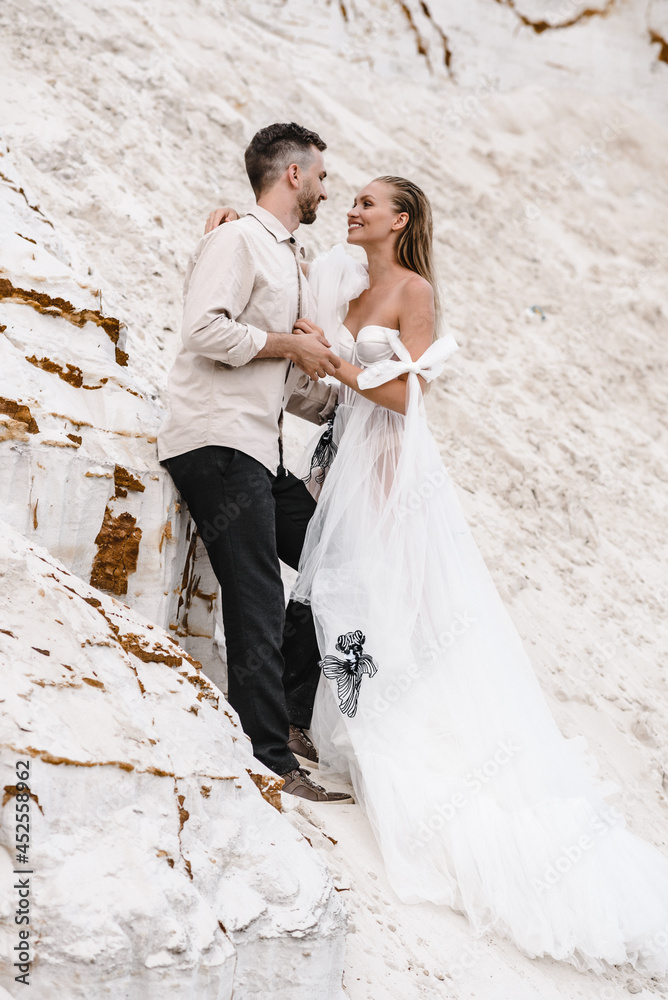 Beautiful wedding couple bride and groom at wedding day outdoors at ocean beach. Happy marriage couple o Beautiful wedding couple bride and groom at wedding day outdoors at ocean beach. Happy marriage couple o