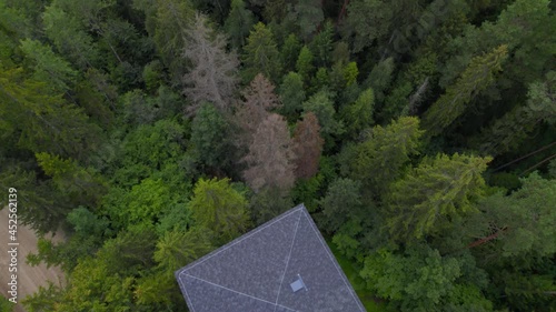 Beautiful bird's eye view of the green forest, blue lake, green grass and blue sky. The camera looks down at the observation tower and slowly moves up to the forest.Latvia National Park Lielie Kangari photo