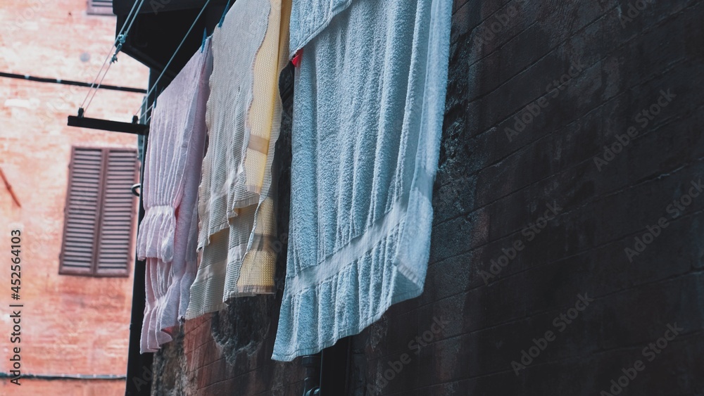 Drying Wet Laundry Hanging Outside Window in Italian City Alley	