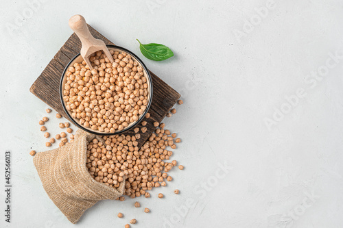 A bowl with raw chickpeas on a gray background. Organic, healthy ingredients. Top view, copy space.