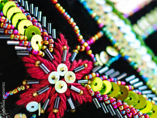Fragment of ornate embroidered black velvet with colorful glass beads, bugles and spangles