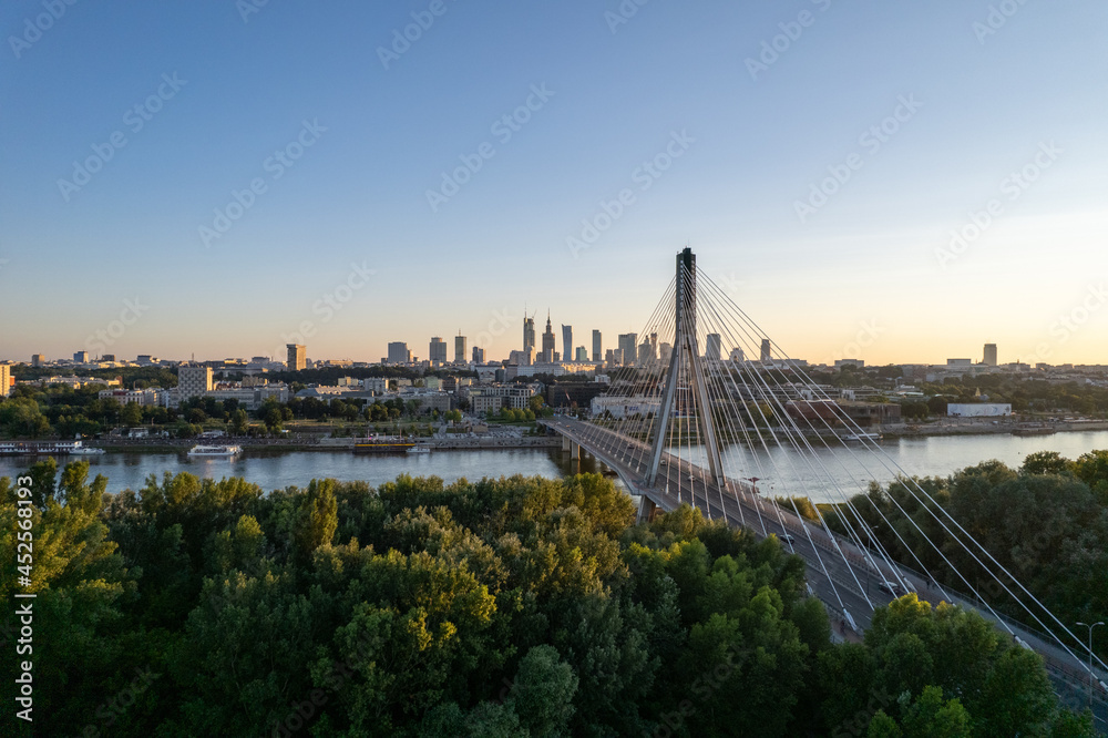 Widok na wieżowce w centrum Warszawy o zachodzie słońca, złota godzina, nad mostem świetokrzyskim - obrazy, fototapety, plakaty 