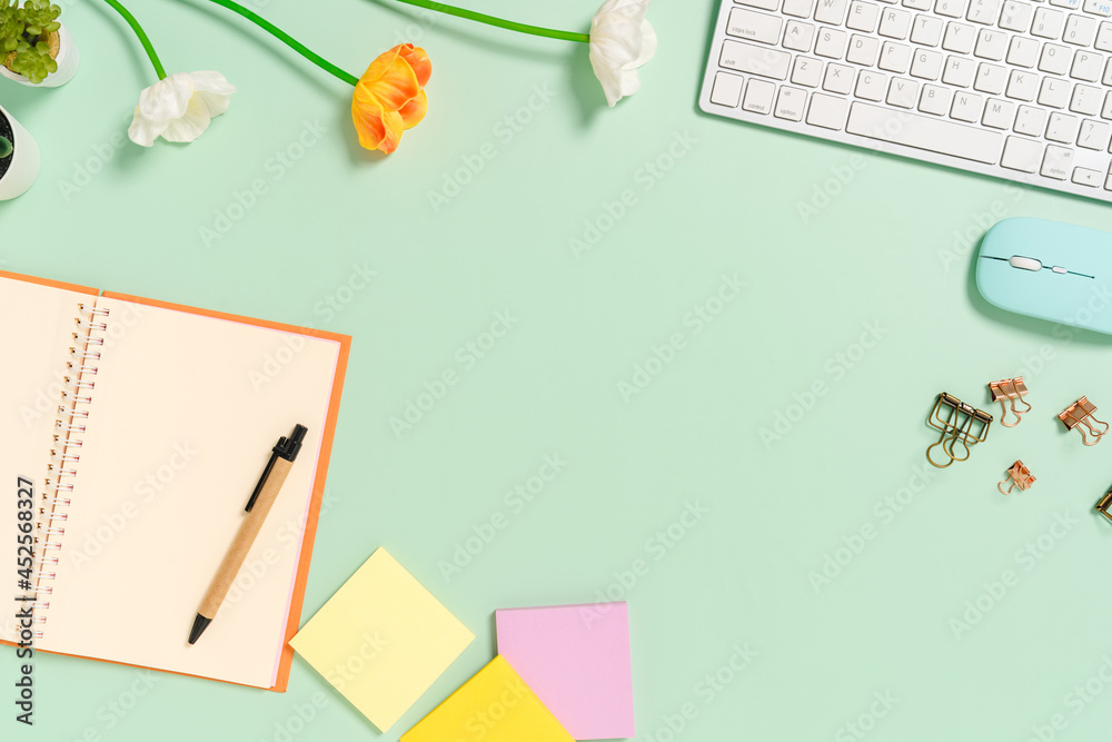 Creative flat lay photo of workspace desk. Top view office desk with keyboard, mouse and open mockup black notebook on pastel green color background. Top view mock up with copy space photography.