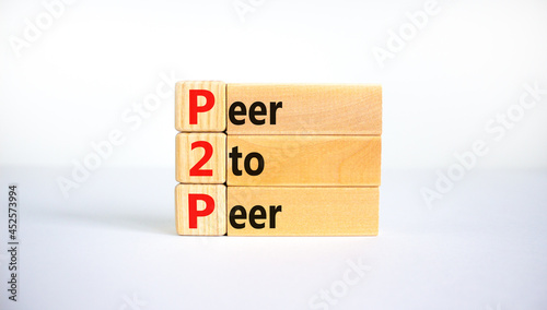 P2P, peer to peer symbol. Wooden blocks with concept words 'P2P, peer to peer'. Beautiful white background, copy space. Business and P2P, peer to peer concept.