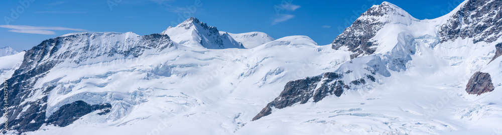 panorama sur des cimes de montagnes enneigées sous un ciel bleu