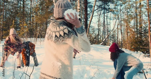 Idyllic cinematic shot, happy friends enjoying snowball fight at magnificent snowy winter forest with dog slow motion.