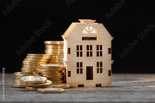 money background, coins and house model on wooden background, bank loan concept, real estate agent, home insurance photo