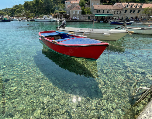 Small boat suspended by the turquoise water of Adriatic Sea. photo