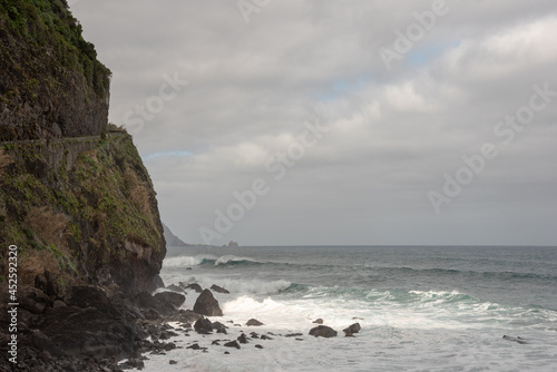 Waves crashing on the rocks. Atlantic Ocean shore in Sao Vicente, north of Madeira Island. High cliff. Selective focus. 