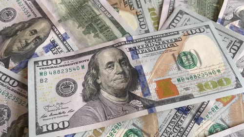 Hand putting 100 US Dollar on background with banknotes od hundreed dollars USA. Close. up. Financial concept. 4K