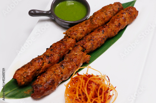 lamb or mutton seekh kebab (mince mutton meat skewer) served with mint chutney, indian street food.