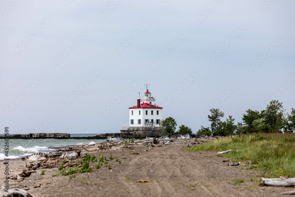Fairport Harbor West Breakwater Lighthouse on Lake Erie coastline with driftwood