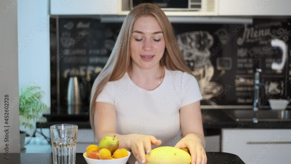 Woman sniffs fresh yellow mango Woman sniffs fresh yellow mango