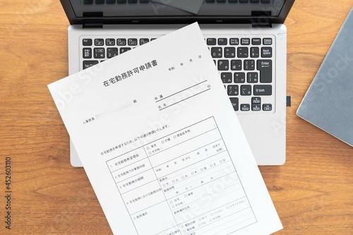 ノートブックPCに置かれた人事部長宛てに作成した在宅勤務許可申請書