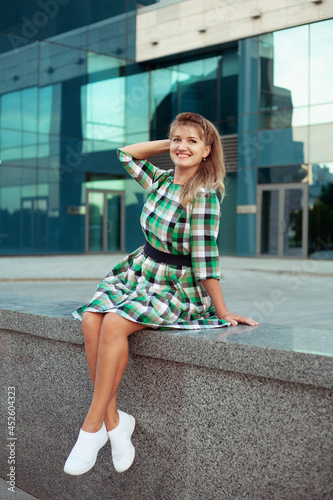 Happy woman in summer city in short dress