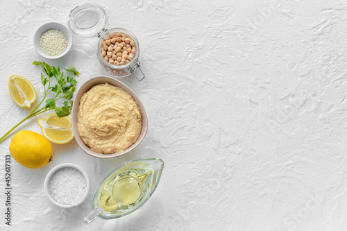 Composition with tasty hummus and ingredients on light background