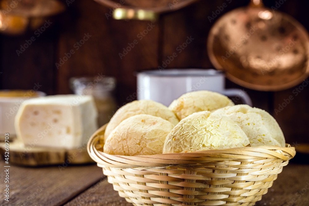 Brazilian cheese bread basket, with cheese in the background and coffee, a Brazilian tradition Brazilian cheese bread basket, with cheese in the background and coffee, a Brazilian tradition
