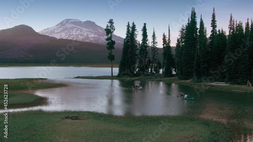 Aerial: Forest and row boat on tranquil waters of Sparks Lake, Oregon photo