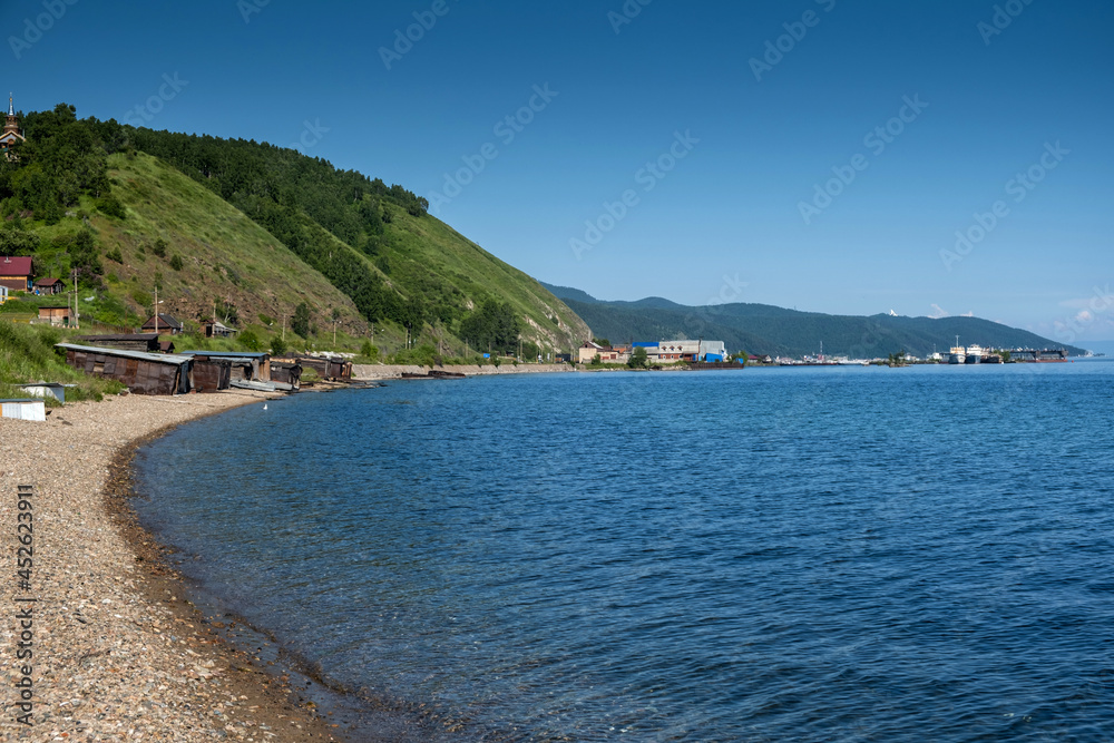 Baikal Lake in summer day. Focus on clear transparent water and coastal stones. Summer travel.
