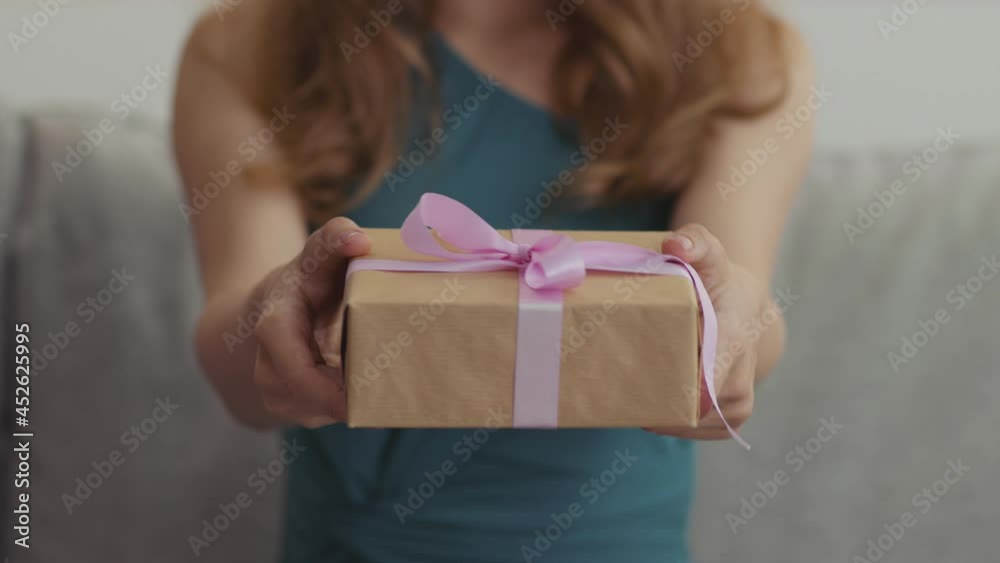 Happy birthday greeting. Close up shot of unrecognizable lady giving holiday gift box to camera Happy birthday greeting. Close up shot of unrecognizable lady giving holiday gift box to camera