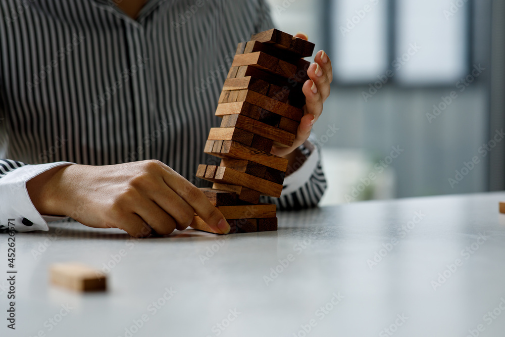 Close up of Hand stopping wooden domino business crisis effect or risk protection concept