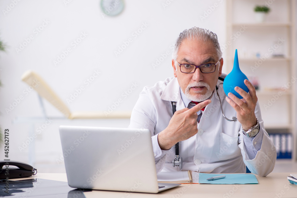 Old male doctor gastroenterologist working in the clinic