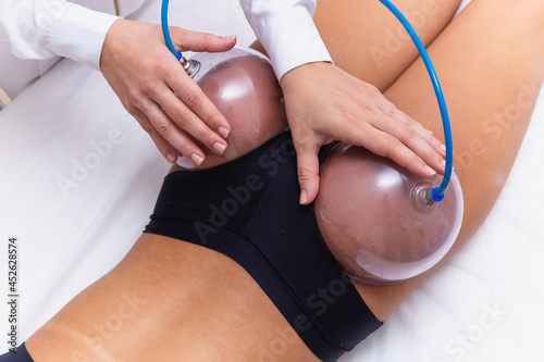 Woman using suction cup pump up on her butt to lift it up.
